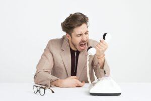 Agitated man screaming into the phone.