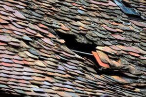 Roof of a house with damaged tiles.