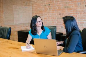 Two women talking about how to sell a home with a property line dispute.