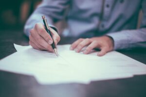 A man signing paperwork.