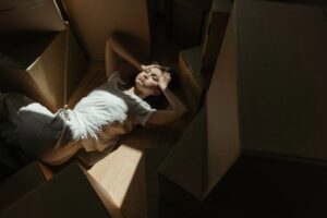 A woman surrounded by moving boxes.