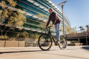 An elderly man riding a bicycle on a sunny day