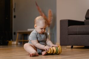 A baby playing with a toy on the floor.