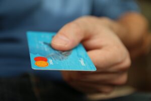 A man holding a blue credit card. 