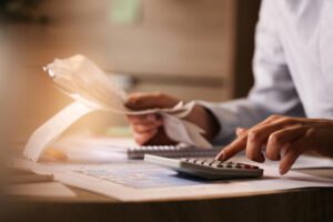 a man holding checks and using a calculator 