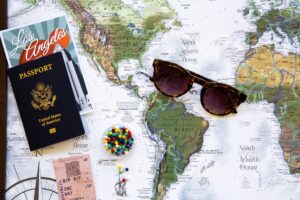 Sunglasses and a US passport on a world map to symbolize traveling with a criminal record