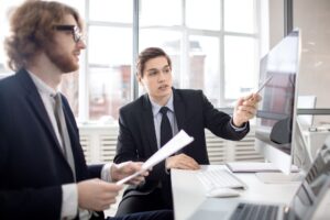Two people looking at computer monitor